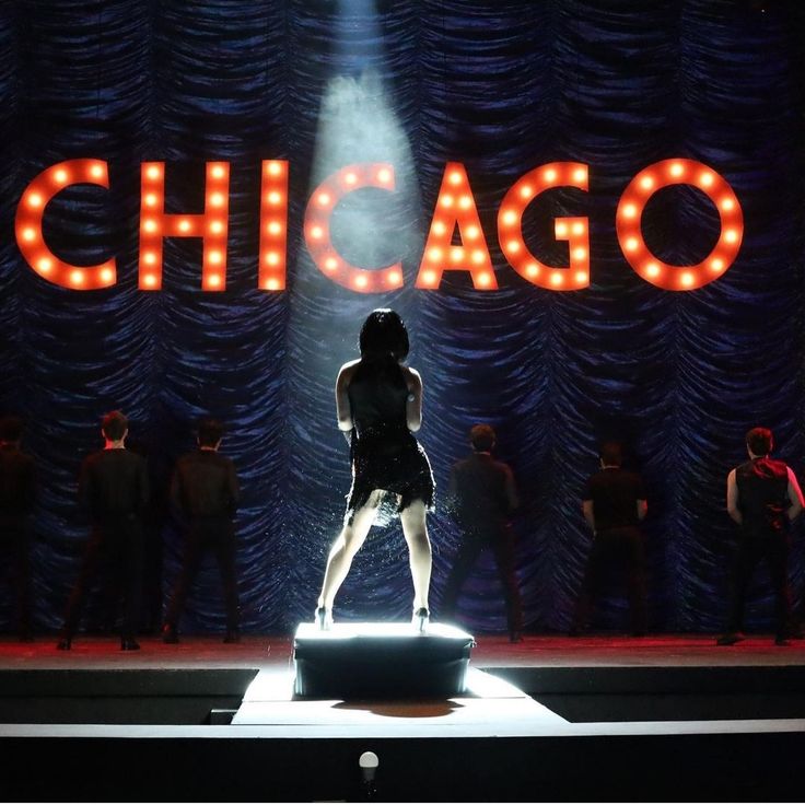 a woman standing on top of a stage in front of a sign that says chicago