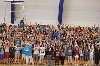 a group of people standing on top of a basketball court with their hands in the air