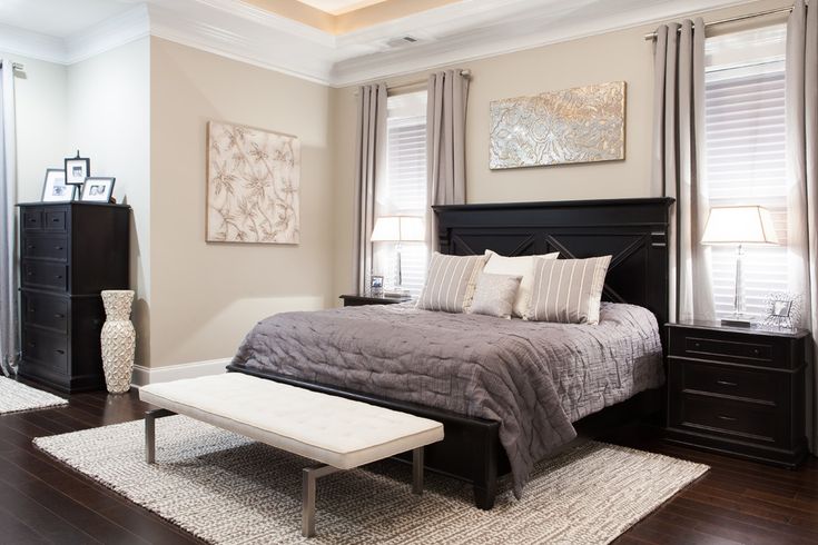 a large bedroom with hardwood floors and white walls, along with dark wood flooring