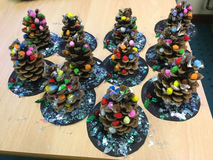 several pine cones are sitting on top of small plates covered in beads and glitters