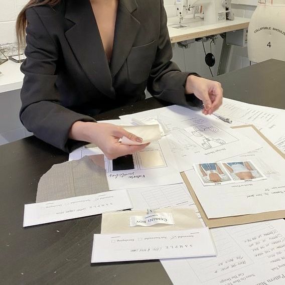 a woman sitting at a table with papers on it