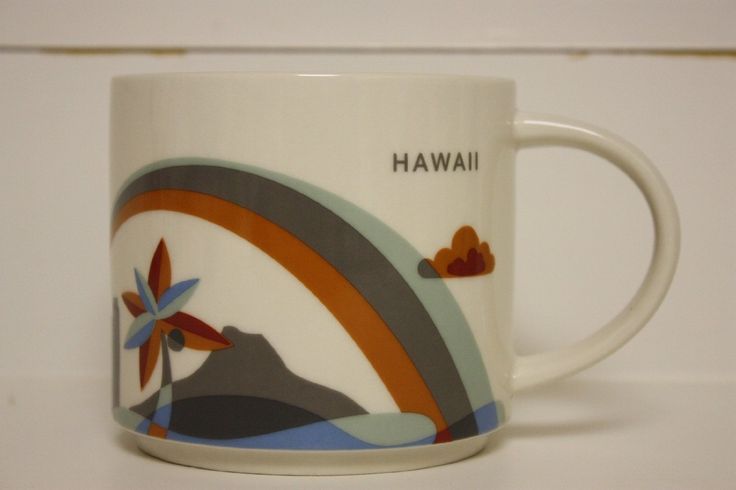 a white coffee mug with an image of a rainbow and mountains in the background that says hawaii