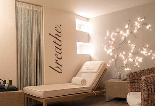 a room with a bed, chair and lights on the wall above it that says relax