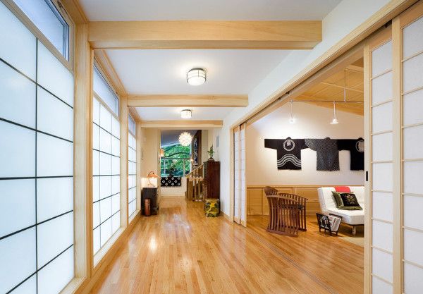 an empty room with wood flooring and white wall coverings on either side of the hallway