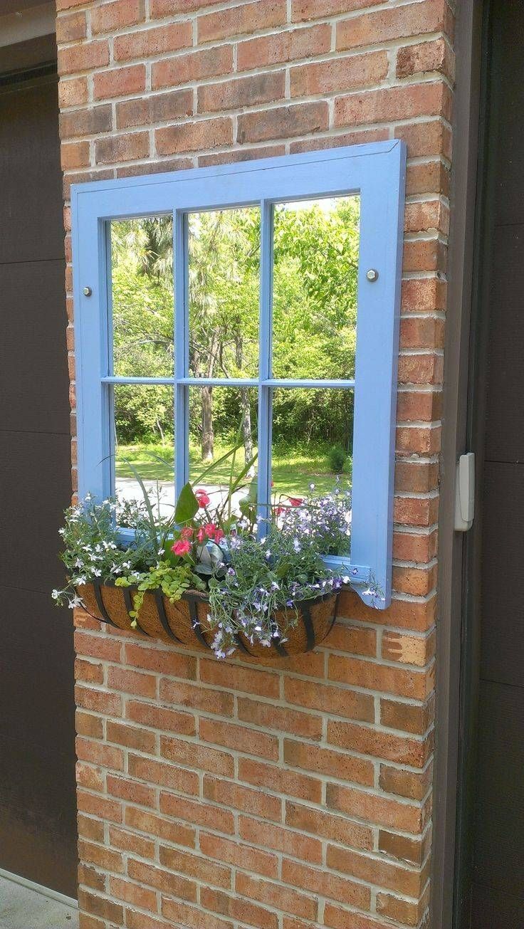 a window box with flowers in it on the side of a brick building