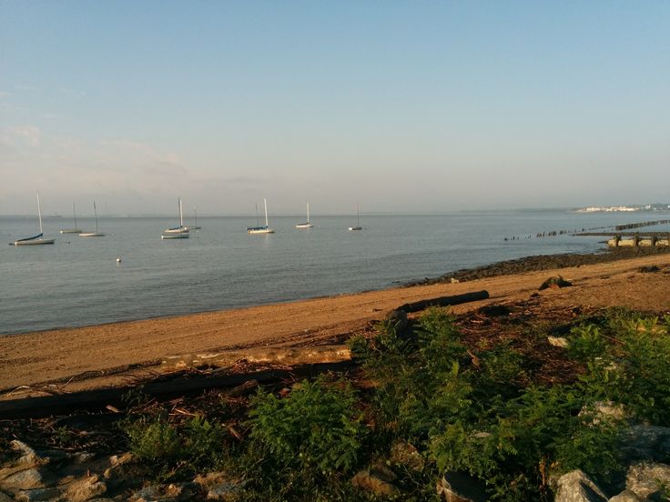 there are many boats that are in the water on this beach, and one is off to the side