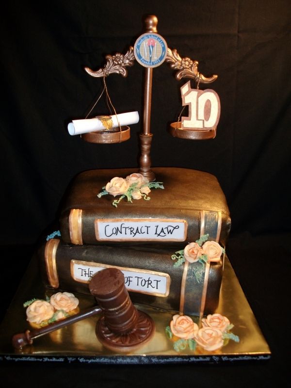 a cake made to look like an old book with a judge's scale on top