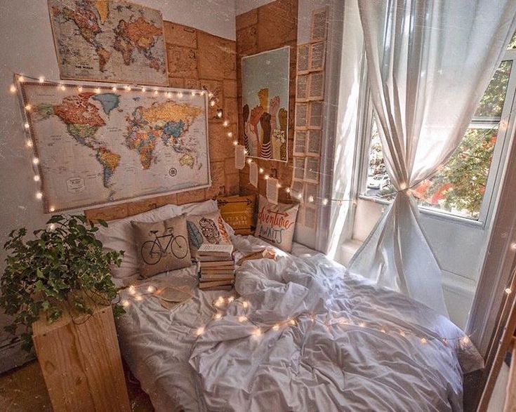 a bed with white sheets and lights on the headboard in a room filled with windows