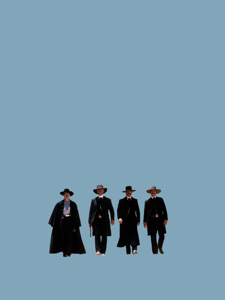 three men in long coats and hats standing next to each other on a blue background