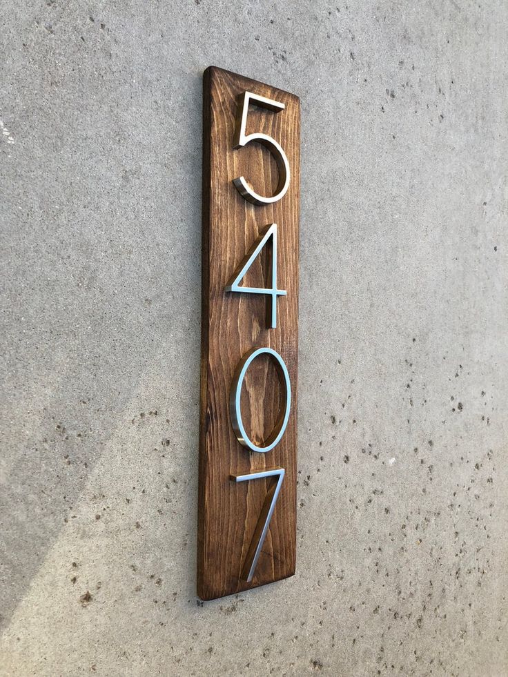 a wooden sign with the number fifty four on it's side that reads 5 / 4