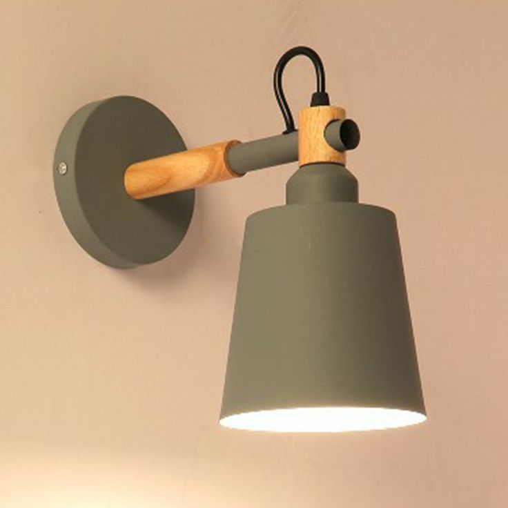 a gray wall light with a wooden arm and grey lamp shade on the left side