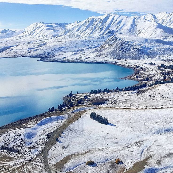 an aerial view of snow covered mountains and lakes