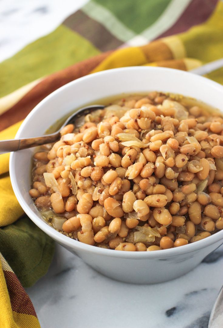 a white bowl filled with beans on top of a table