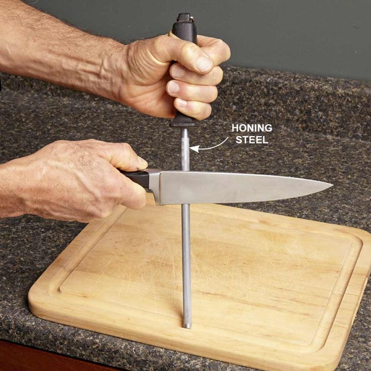 a man is holding a knife on top of a cutting board with the handle extended