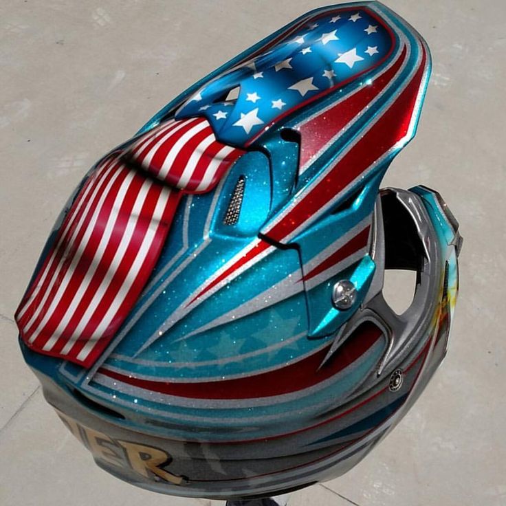 a motorcycle helmet with an american flag design on the front and side, sitting on top of a metal stand