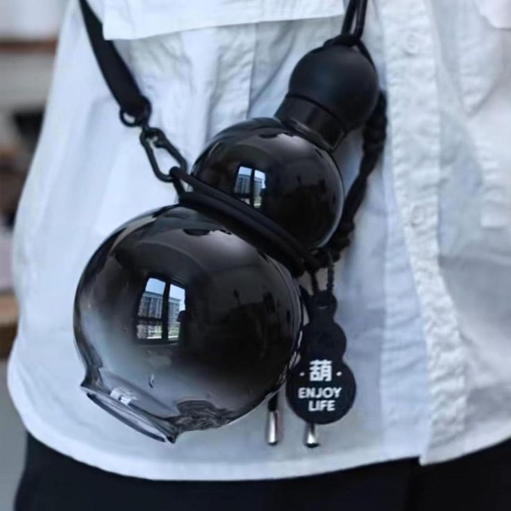 two black helmets are attached to the back of a man's white button up shirt