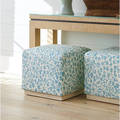 two blue and white foot stools sitting on top of a wooden floor next to a table