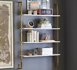 a white shelf with books and pictures on it next to a wall mounted art piece