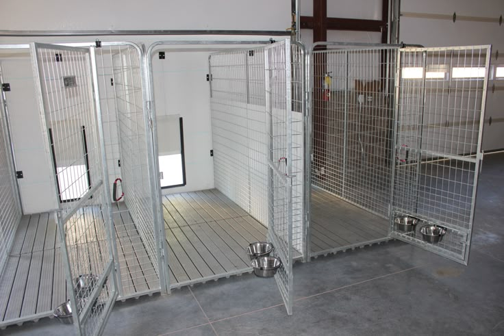 three metal stalls with doors open in an empty room