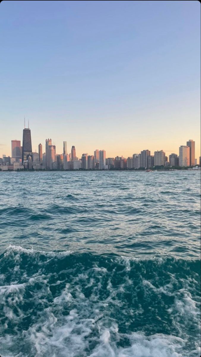 the city skyline is seen from the water in this photo taken on a sunny day