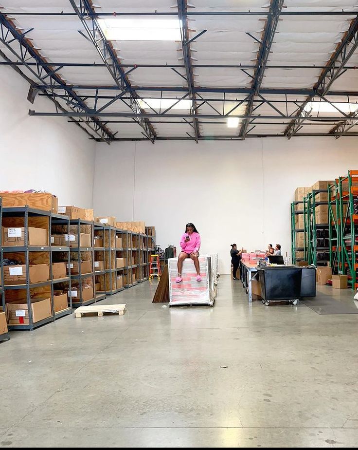 a woman standing on top of a box in a warehouse