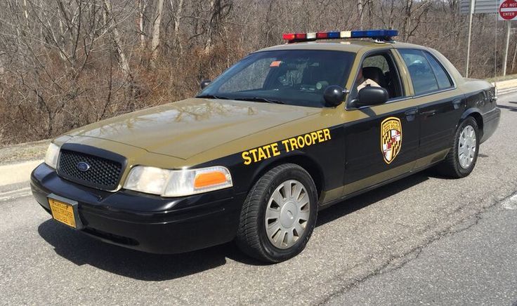 a state trooper car is parked on the side of the road