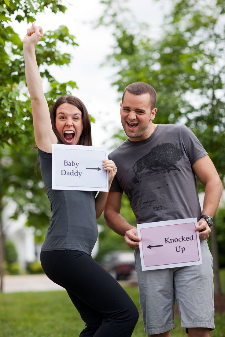 a man and woman holding up signs in the air