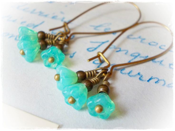 Three little mint opal flowers, dangle beneath elongated kidney wires.. These long earrings are lightweight and fun to wear. Made of Czech glass flower beads, and antiqued brass findings, the length is 1-11/18inches (44mm) including the earring wires. Enter my shop here: https://www.etsy.com/shop/karmelidesigns Green Flower Earrings, Czech Beads Jewelry, Dainty Dangle Earrings, Mint Green Flowers, Purple Drop Earrings, Lavender Earrings, Black Earrings Dangle, Porcelain Earrings, Flower Drop Earrings