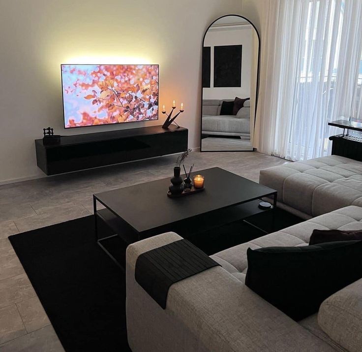 a living room filled with furniture and a flat screen tv on top of a wall