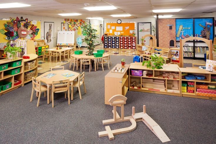 a classroom filled with lots of wooden tables and chairs