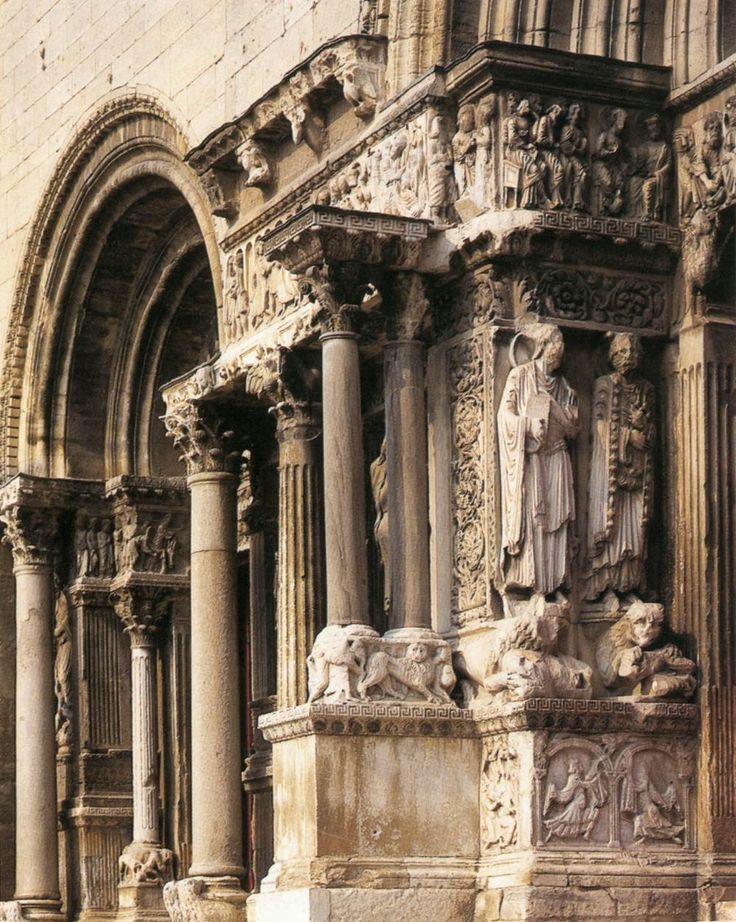 an old building with columns and statues on the outside