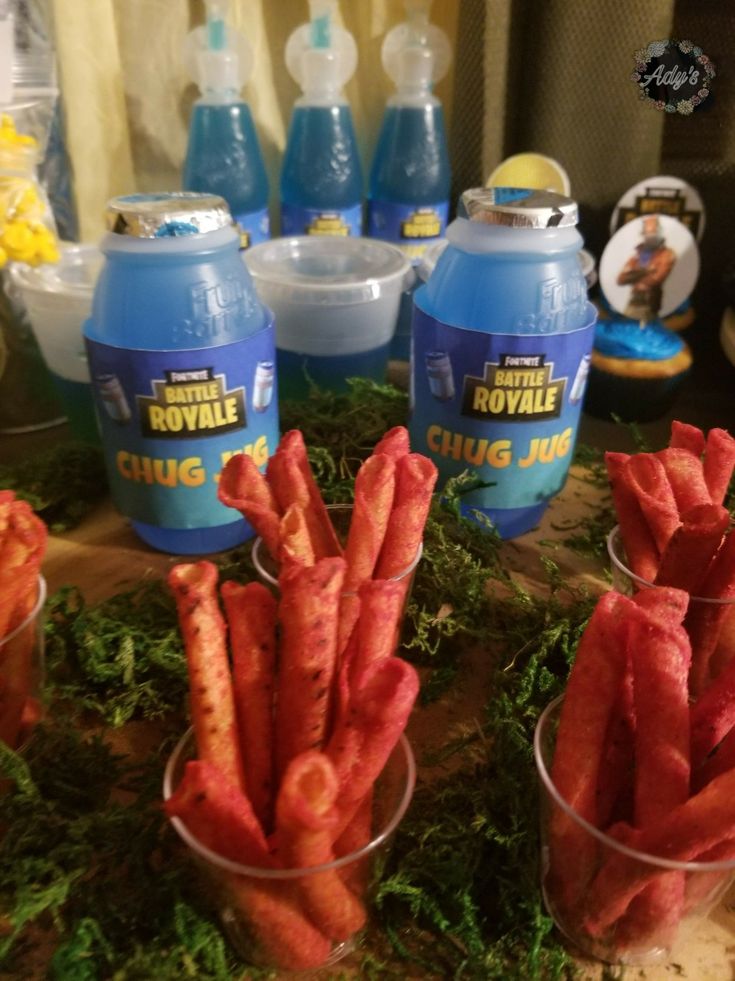 carrot sticks are in cups on a table