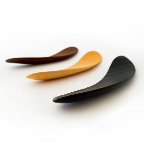 three wooden spoons sitting next to each other on a white surface