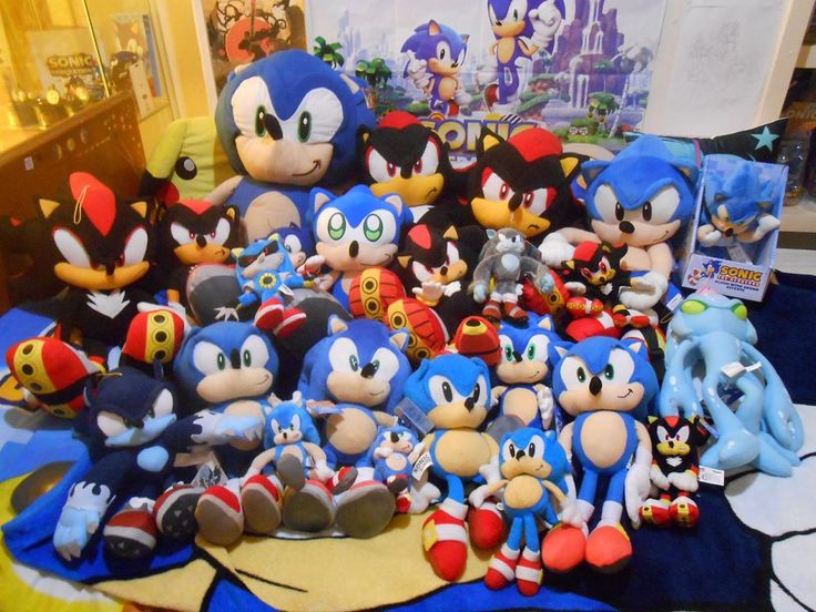 a pile of sonic the hedgehog stuffed animals on a table with other plush toys