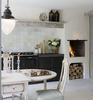 a dining room table and chairs with a fireplace in the backround behind it