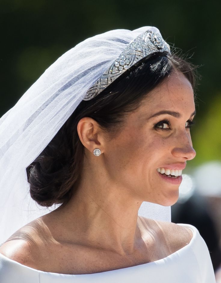 the bride is wearing a tiara and smiling