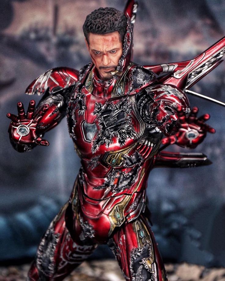 the action figure is posed in front of a backdrop with an image of a man holding two swords