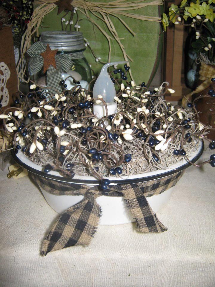 a bowl filled with blue berries and other decorations