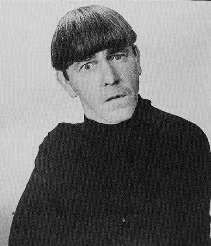 an old black and white photo of a man in a turtle neck sweater looking at the camera