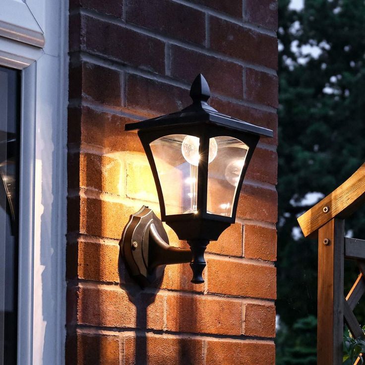 an outdoor light on the side of a brick building