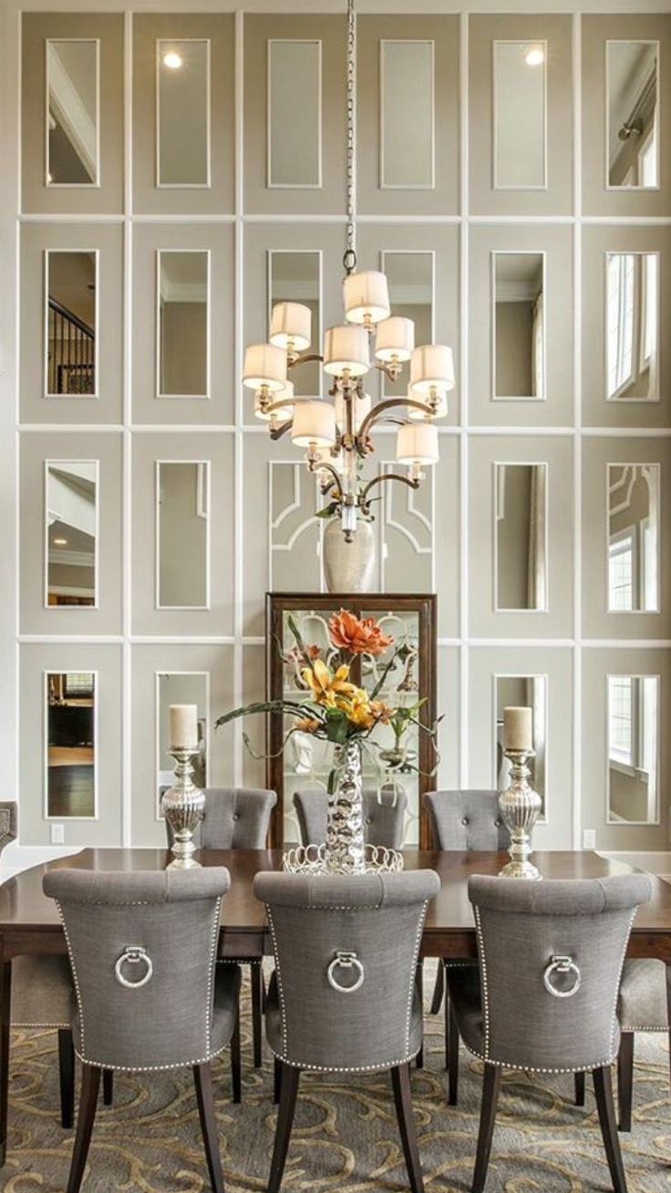 a dining room table with chairs around it and a chandelier hanging from the ceiling