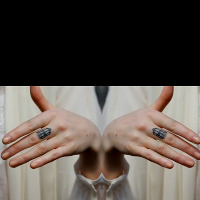 two hands with rings on their fingers in front of a woman's face and dress