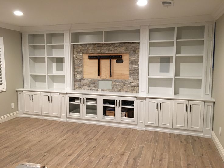 an empty room with built - in cabinets and shelves on the wall, along with wood flooring