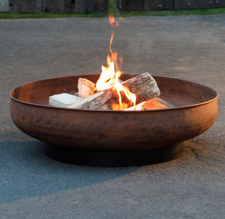 a fire pit sitting on top of a cement ground