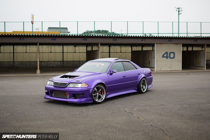 a purple modified car parked in a parking lot