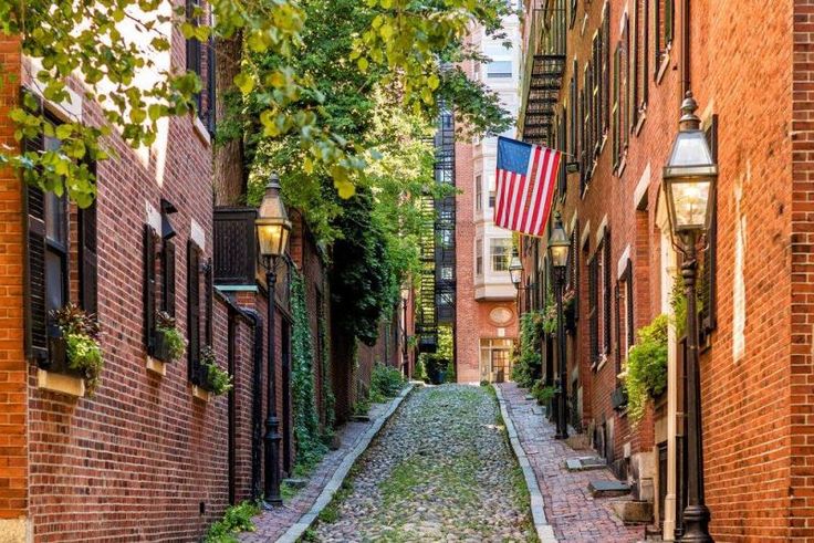 an alley way with brick buildings and flags on it