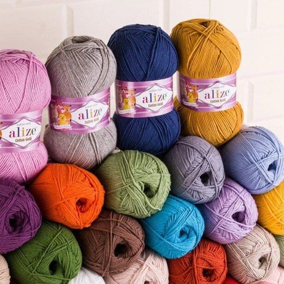 many balls of yarn are stacked on top of each other in different colors and sizes