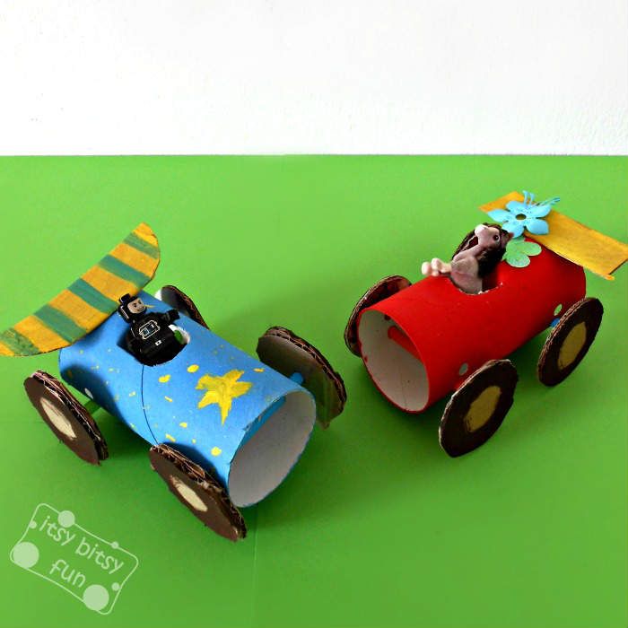 two paper cars are sitting on a green surface