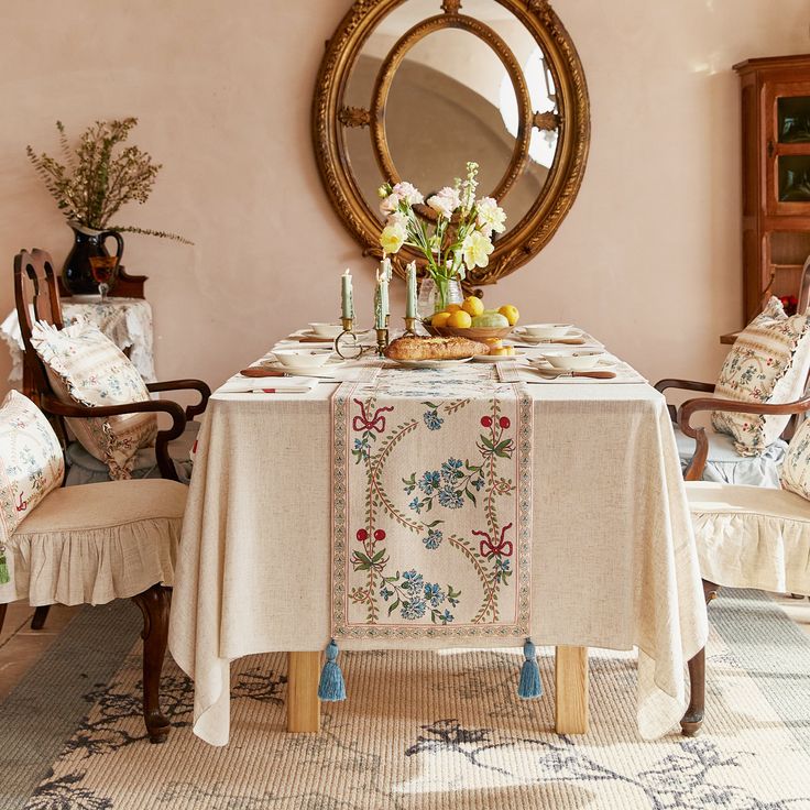 a dining room table with a mirror on the wall