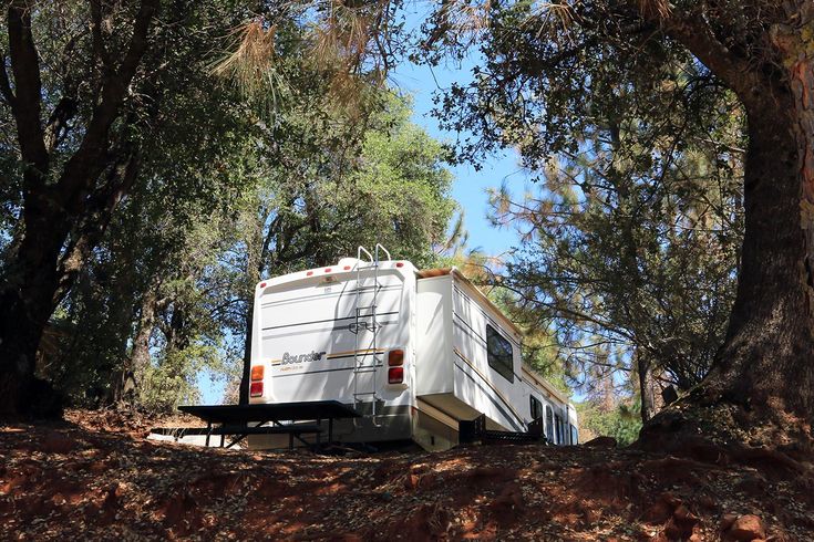 an rv is parked in the middle of some trees